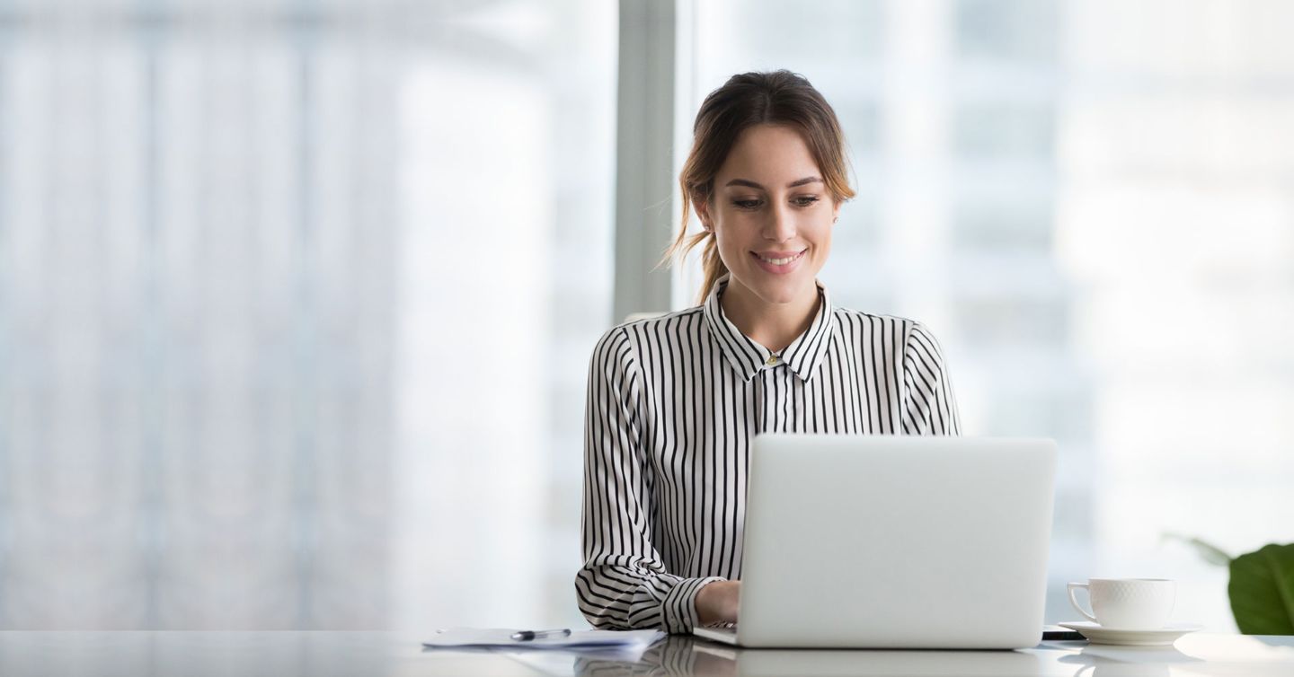 Woman in a stripped shirt looking at a laptop