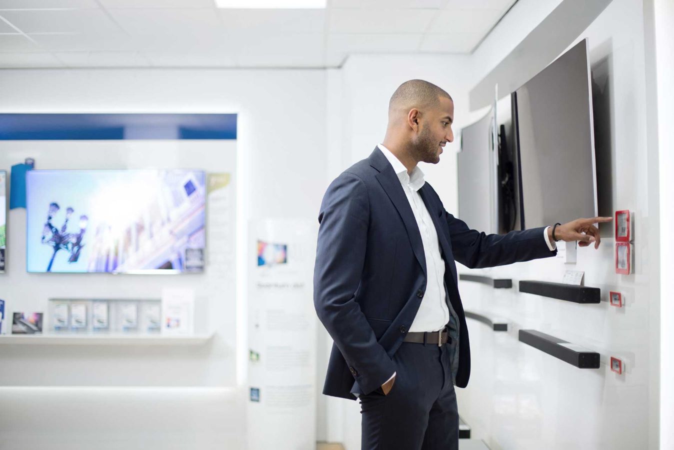 man in a store looking at a TV